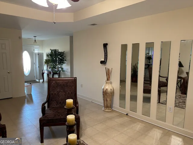a view of a hallway with wooden floor and a potted plant