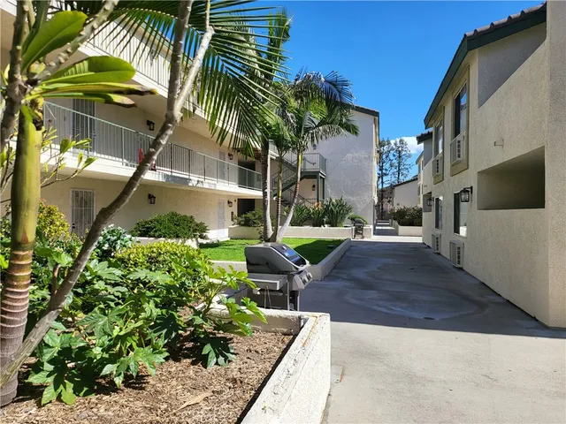 a view of a backyard with couches under an umbrella