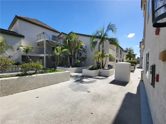 a view of a patio with a dining table and chairs under an umbrellas