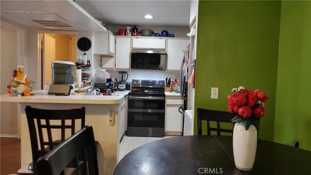 a kitchen with stainless steel appliances kitchen island granite countertop a sink dishwasher and a microwave with wooden floor