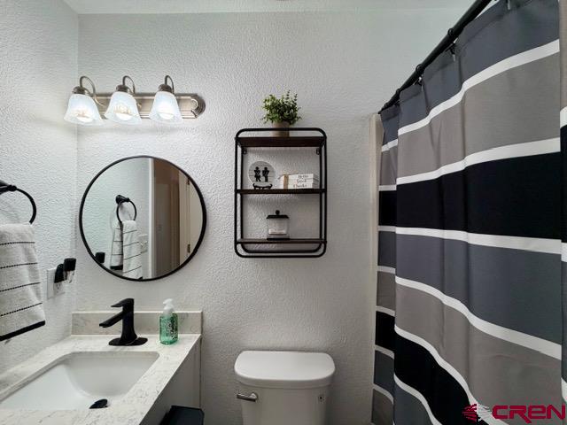 544 20th Street Delta, CO 81416 - Photo 27 of 44 a bathroom with a toilet sink and mirror