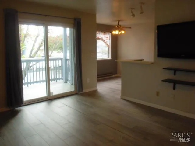 a view of a livingroom with wooden floor and a window