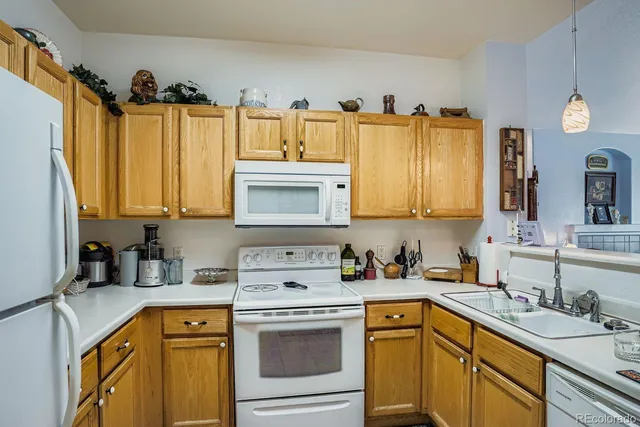 a kitchen with granite countertop a sink a stove and cabinets