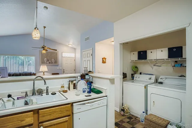 a view of a kitchen with sink and dishwasher with wooden floor