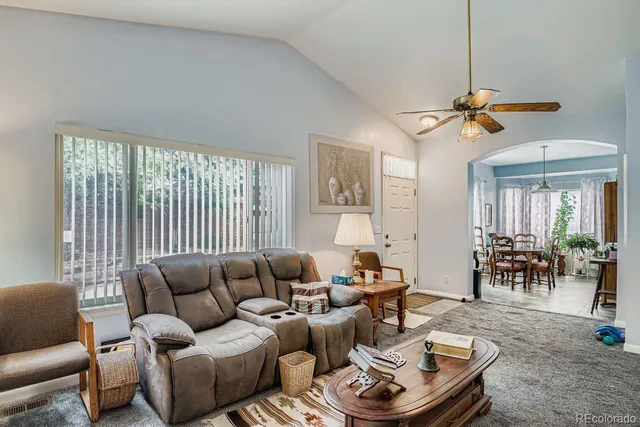 a living room with furniture a dining table and a chandelier