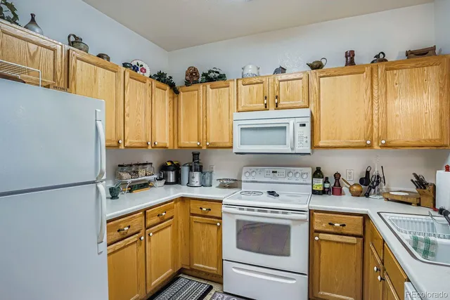 a kitchen with stainless steel appliances granite countertop a sink a stove a refrigerator and cabinets