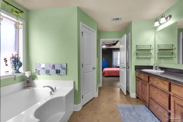 a en suite bathroom with a tub sink and mirror