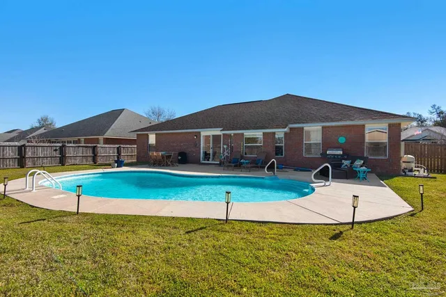 a view of a house with swimming pool and a yard