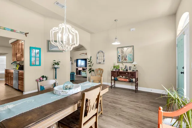 a view of a dining room with furniture a chandelier and wooden floor