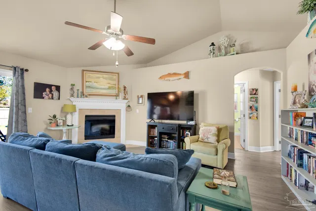 a living room with furniture a bookshelf and a flat screen tv