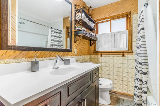 a bathroom with a sink a toilet and shower curtain