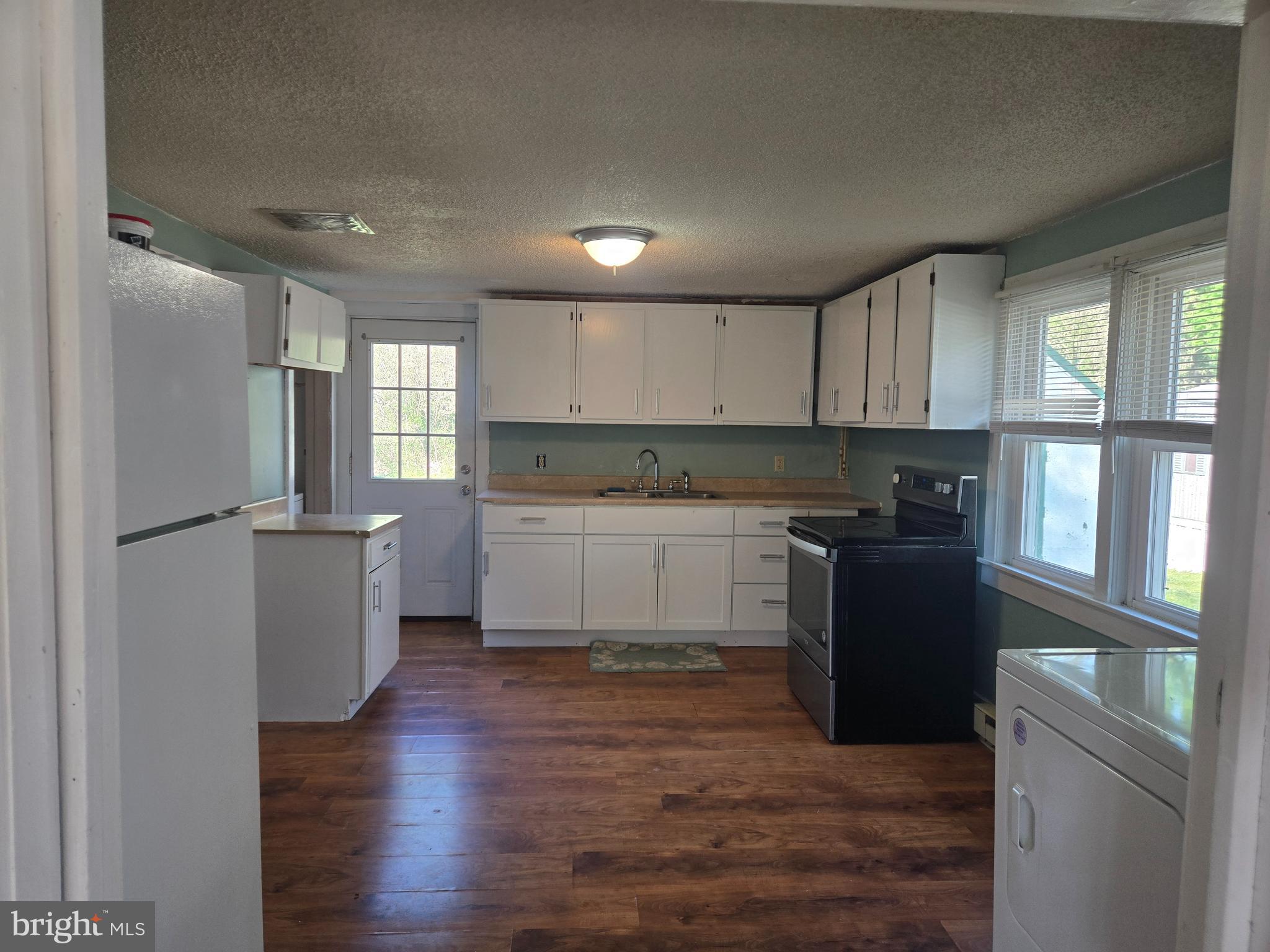 37 Asbury Avenue Dover, DE 19901 - Photo 3 of 16 a kitchen with granite countertop a refrigerator and a stove top oven
