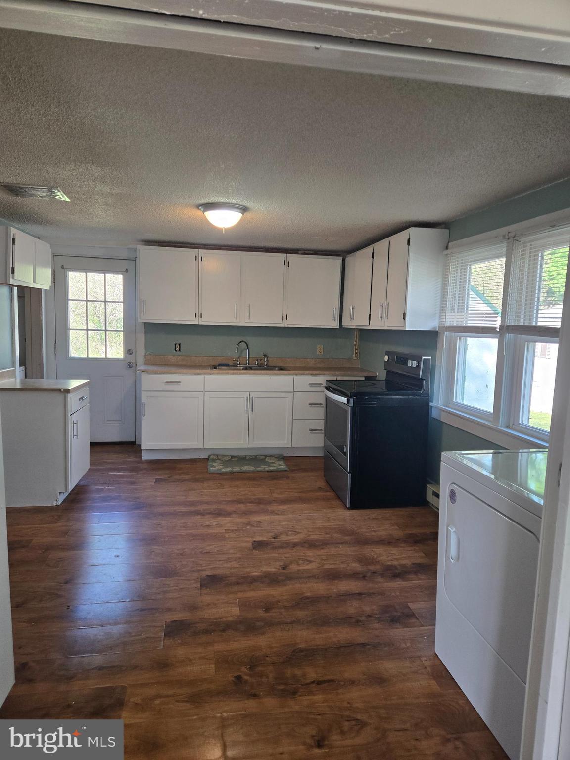 37 Asbury Avenue Dover, DE 19901 - Photo 5 of 16 a kitchen with granite countertop a stove top oven a sink and dishwasher with wooden floor