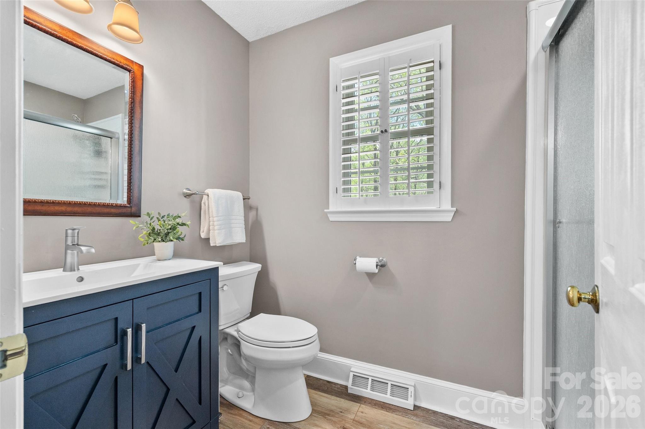 10500 Doylestown Road Matthews, NC 28105 - Photo 21 of 46 a bathroom with a toilet a sink a mirror and a window