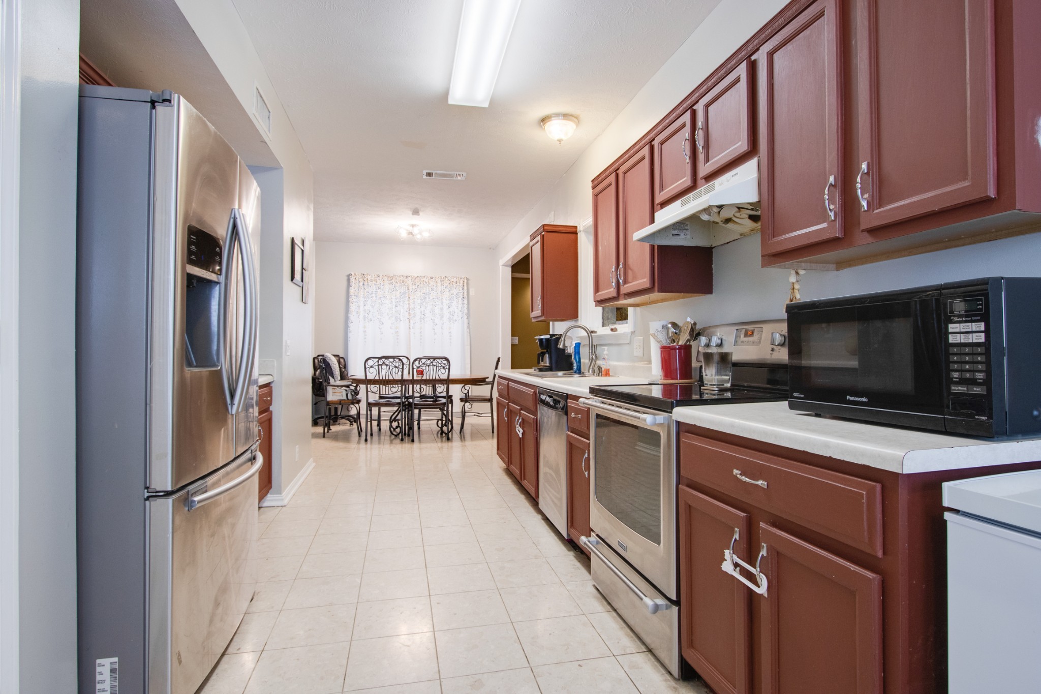 2832 Rader Ridge Court Antioch, TN 37013 - Photo 5 of 26 a kitchen with stainless steel appliances granite countertop a refrigerator oven a sink dishwasher and white cabinets with wooden floor