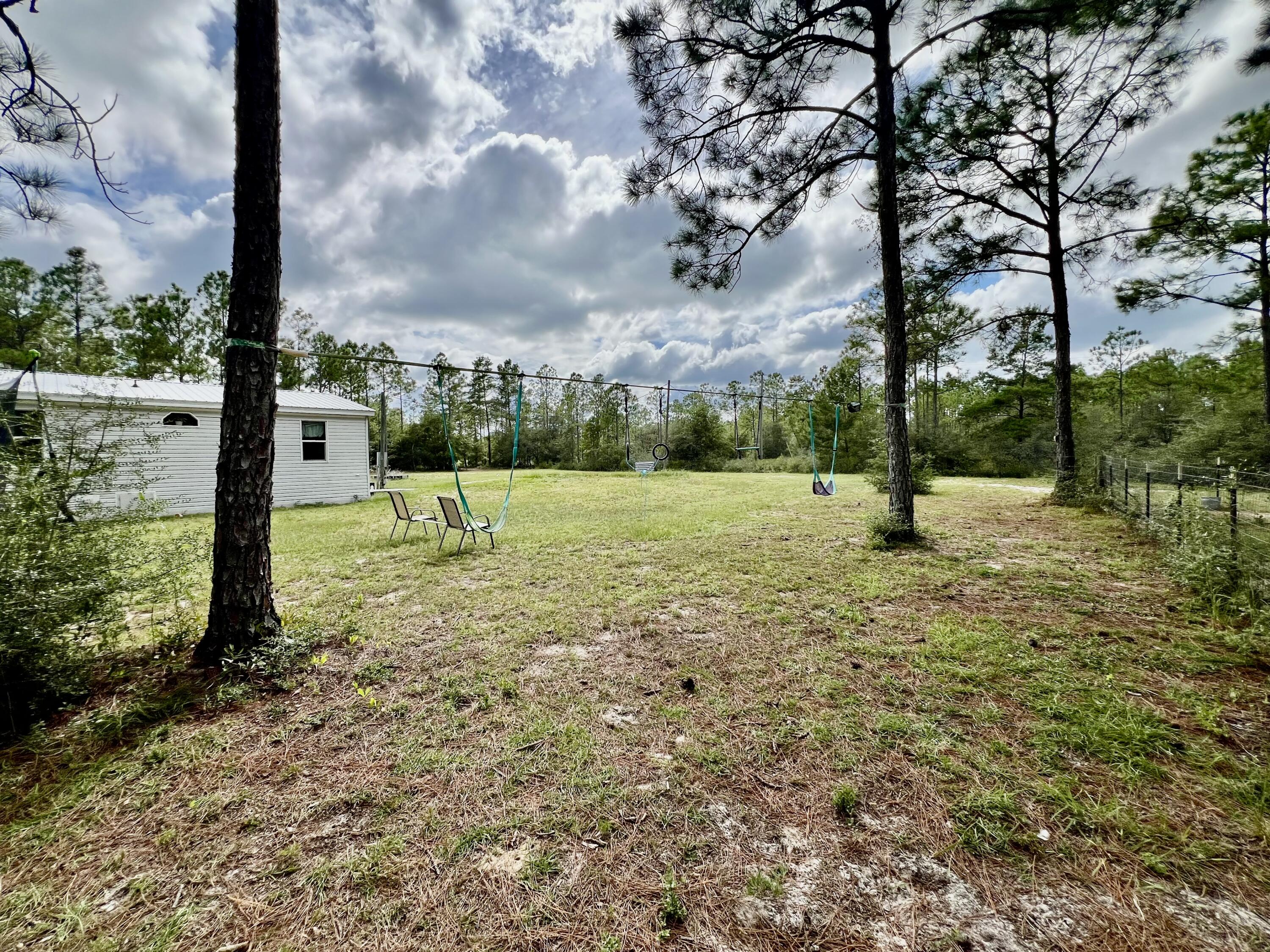 403 Don Graff Road Freeport, FL 32439 - Photo 26 of 34 a view of a field with a tree in the background