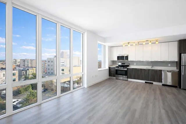 a large kitchen with a large window and wooden floor