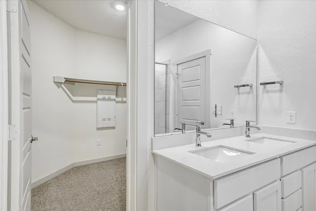 a bathroom with a granite countertop sink a mirror and shower