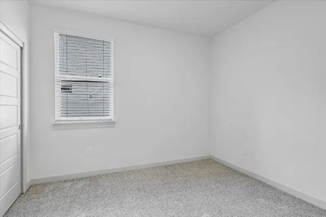 an empty room with closet and a bathroom