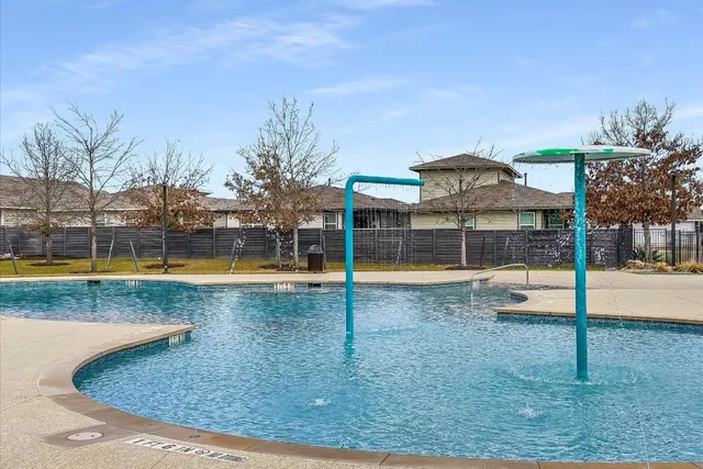 a view of backyard with potted plants and wooden fence