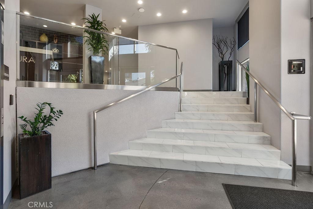 629 Traction Avenue, Unit 312 Los Angeles, CA 90013 - Photo 36 of 45 a view of staircase with white walls and a chandelier