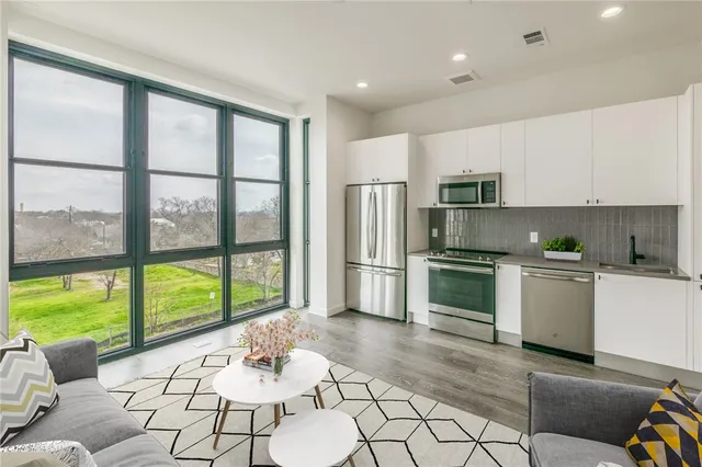 a kitchen with a refrigerator and white cabinets