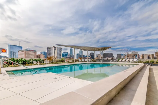 a view of swimming pool with outdoor seating and a garden