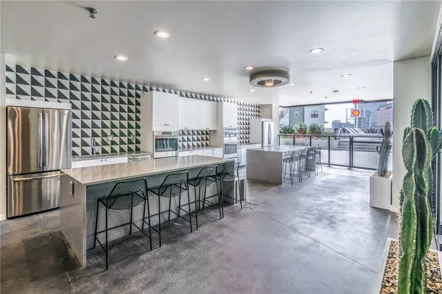 a dining hall with stainless steel appliances a table and chairs