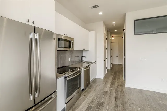 a kitchen with stainless steel appliances a refrigerator and a stove top oven