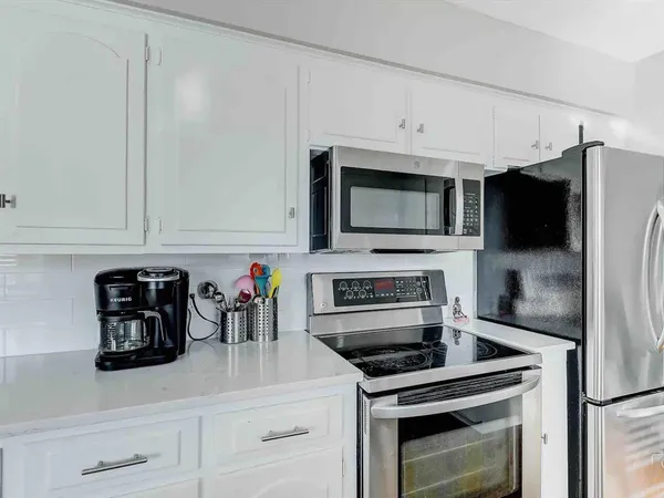 a kitchen with stainless steel appliances a stove microwave and cabinets