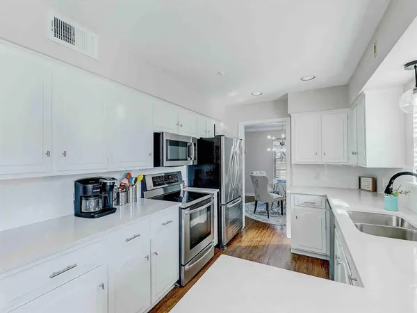 a kitchen with stainless steel appliances granite countertop a sink refrigerator and microwave