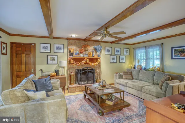 a living room with furniture a fireplace and a window