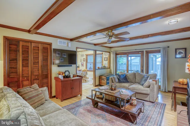 a living room with furniture a flat screen tv and a large window