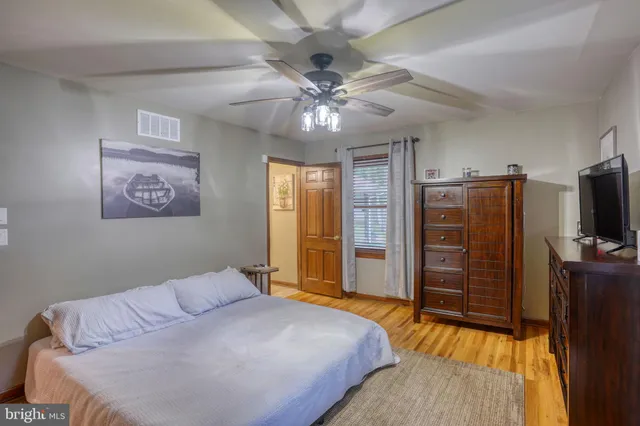 a bedroom with a bed and a flat tv screen on dresser