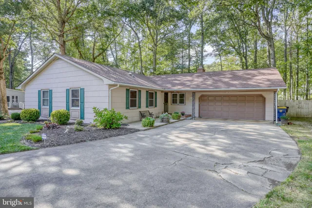 a front view of a house with yard and trees