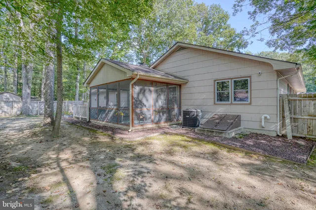 a view of a house with a yard and large tree