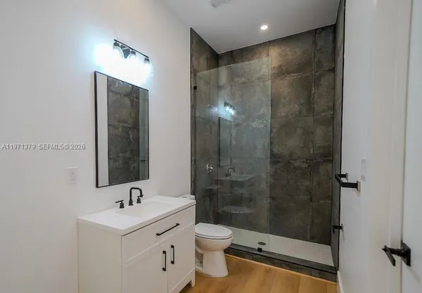 a bathroom with a shower toilet sink and mirror