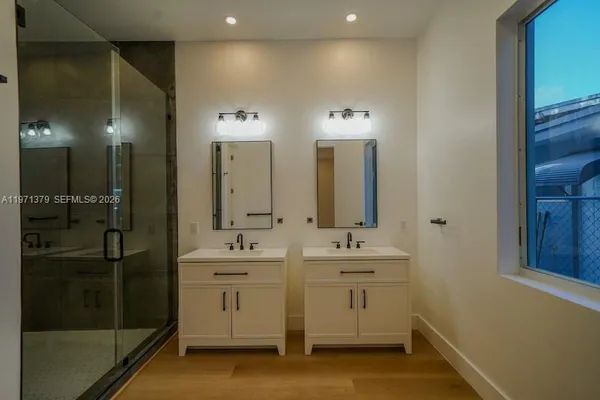 a bathroom with double vanity and a mirror