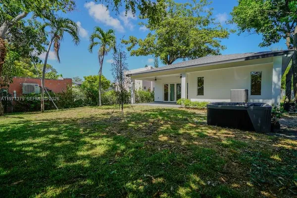 a view of a house with backyard and sitting area