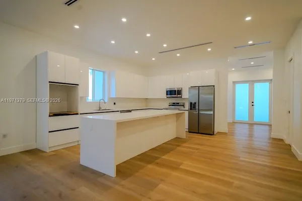 a large kitchen with cabinets and stainless steel appliances