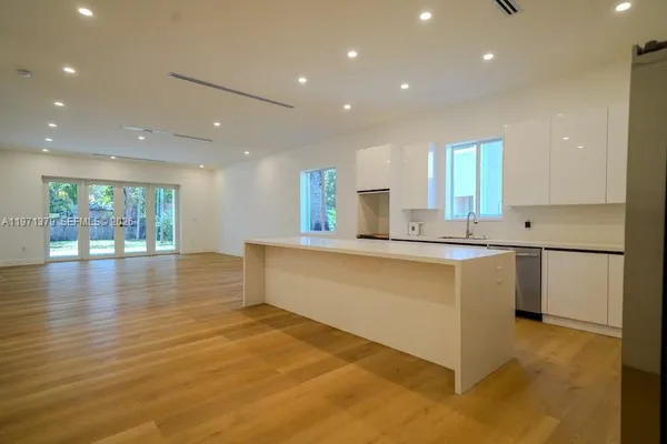 a large white kitchen with a large window