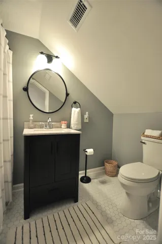 a bathroom with a granite countertop toilet and a mirror
