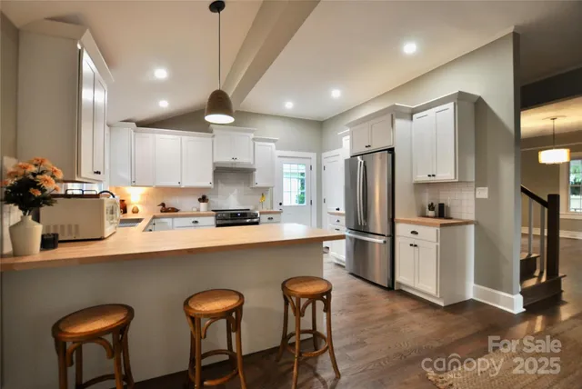 a kitchen with refrigerator and chairs