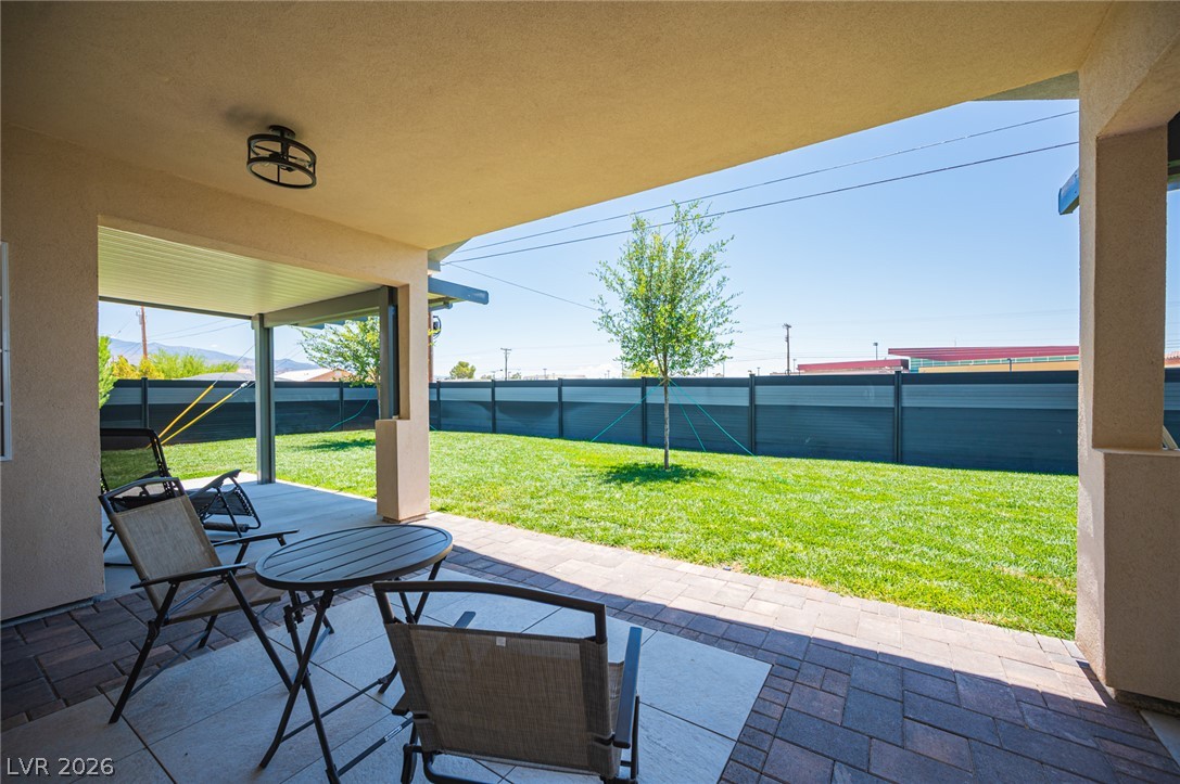 441 Belville Road Pahrump, NV 89048 - Photo 33 of 44 Relax on the covered patio with a paved area, enjoying the private yard with fresh green grass.