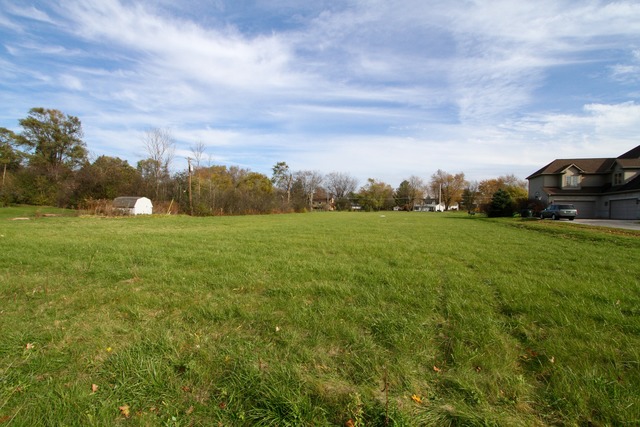 a view of a field with houses in back