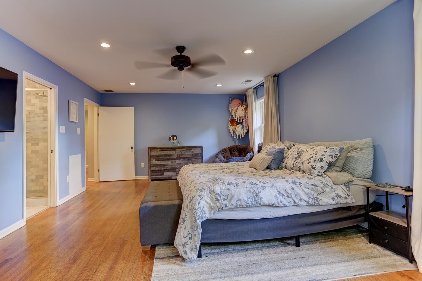 4908 Mockingbird Lane Memphis, TN 38117 - Photo 16 of 21 a bedroom with a bed and a dresser with wooden floor