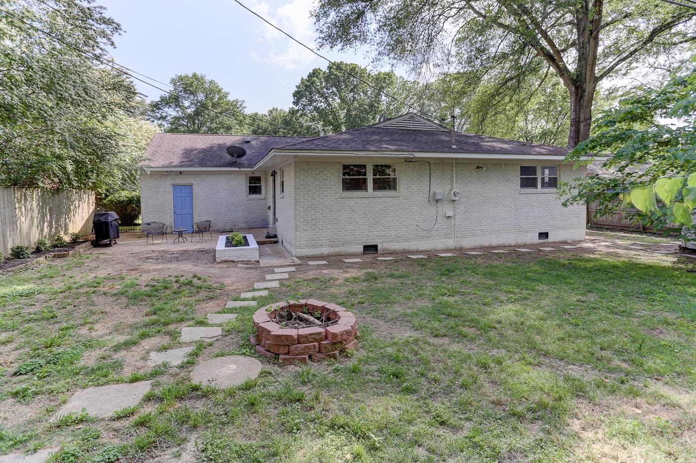 4908 Mockingbird Lane Memphis, TN 38117 - Photo 19 of 21 a view of a backyard with table and chairs and a fire pit