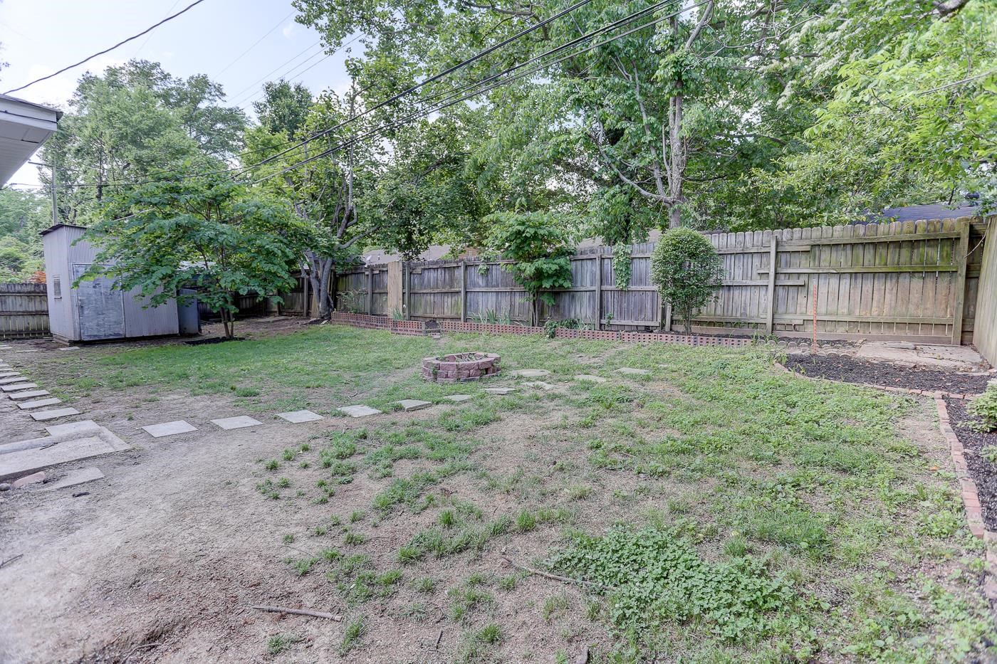 4908 Mockingbird Lane Memphis, TN 38117 - Photo 20 of 21 a view of a backyard with a house and large trees with wooden fence