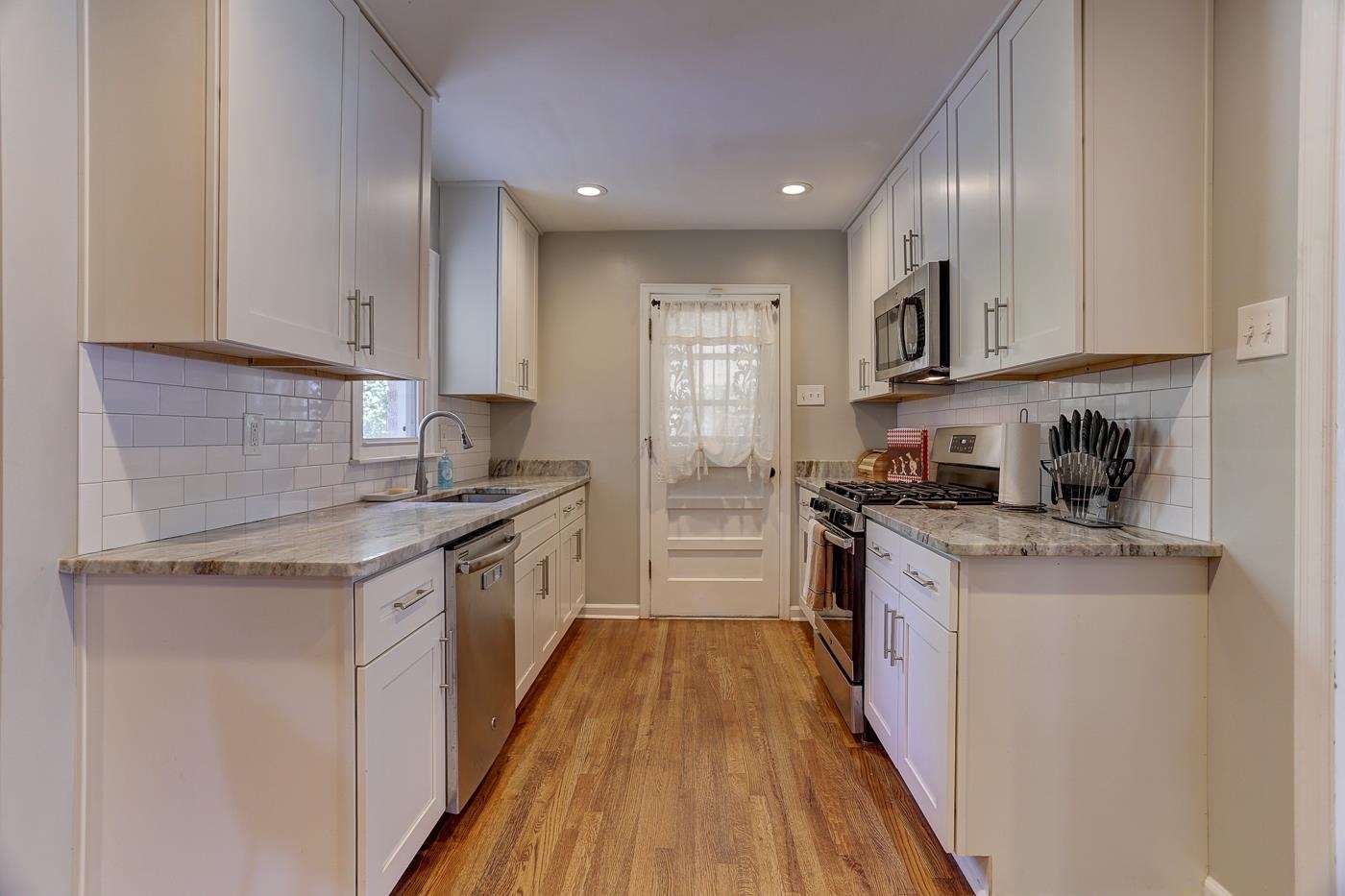 4908 Mockingbird Lane Memphis, TN 38117 - Photo 8 of 21 a kitchen with stainless steel appliances granite countertop wooden cabinets a stove top oven a sink and dishwasher