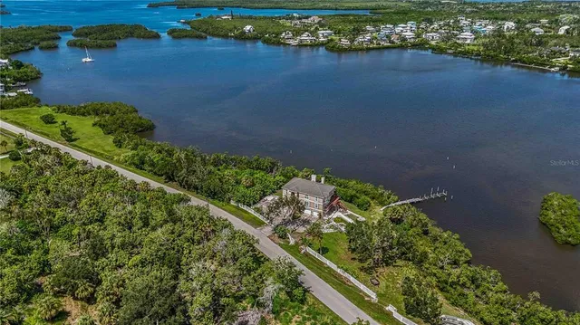 an aerial view of a house with a yard and lake view